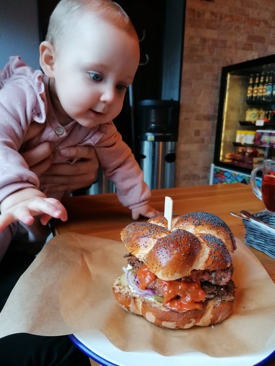 Bobas sięgający ręką do burgera